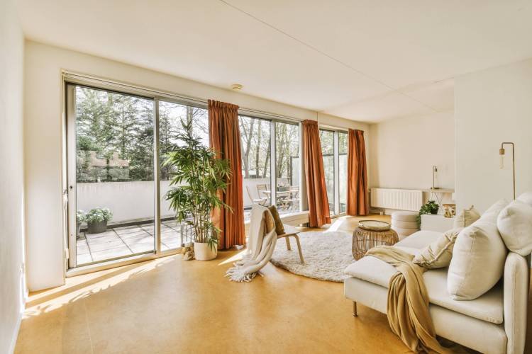 a living room with a couch, chair and large sliding glass door that leads out to the backyard patio area